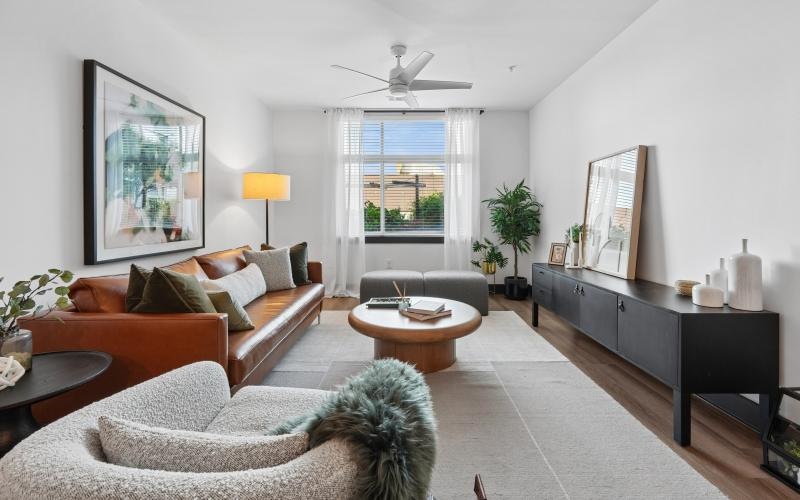 a living room with a couch, tables and a chair